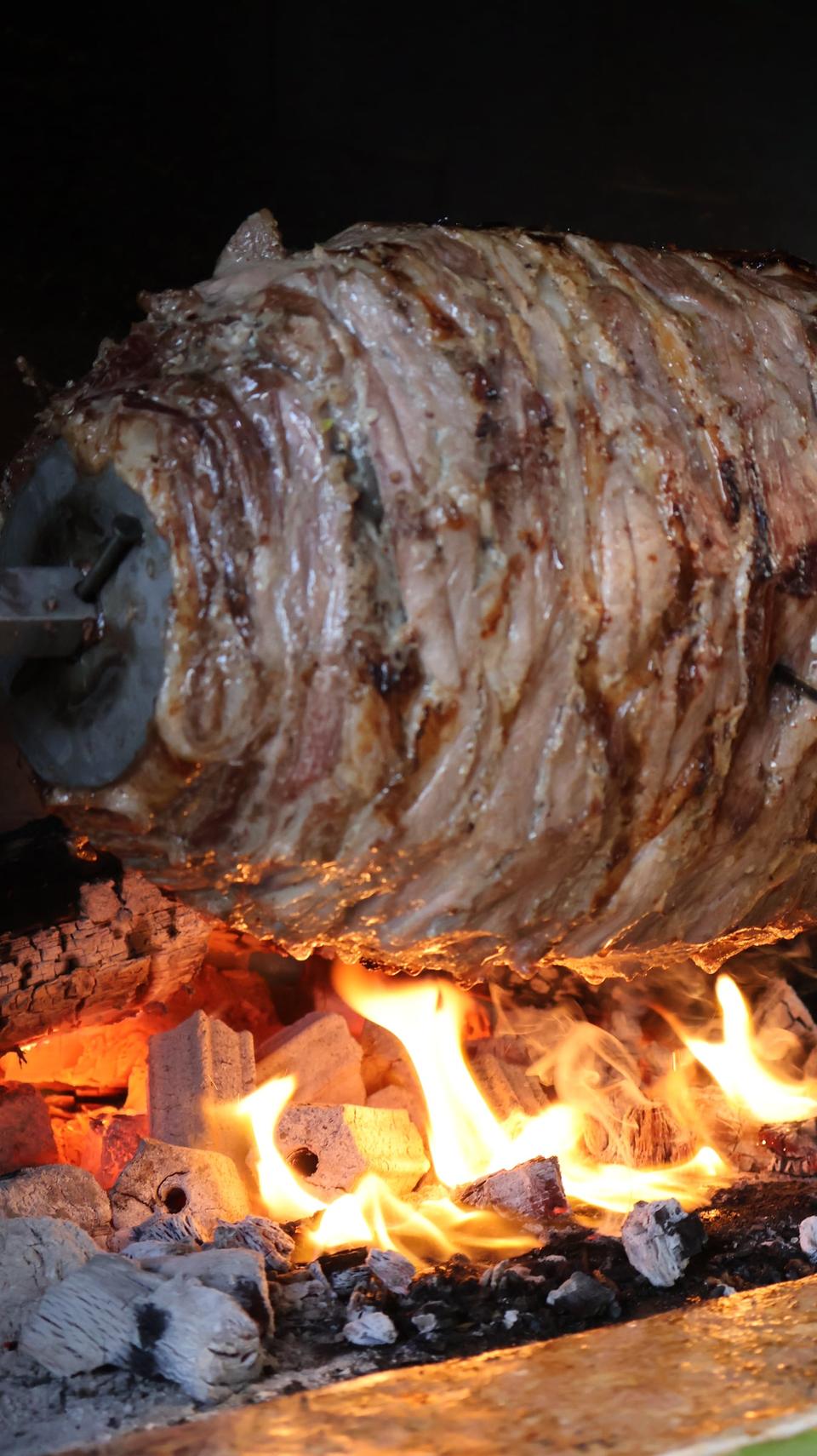 Yatay şişte, odun ateşinin karşısında dönen cağ kebabı